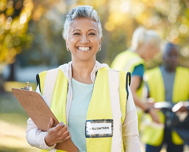Volunteer worker holding clipboard and smiling